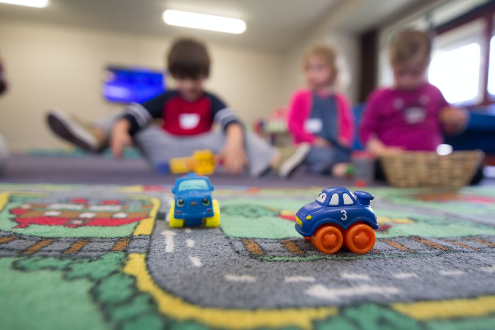 Children Playing with Toy Cars on Mat